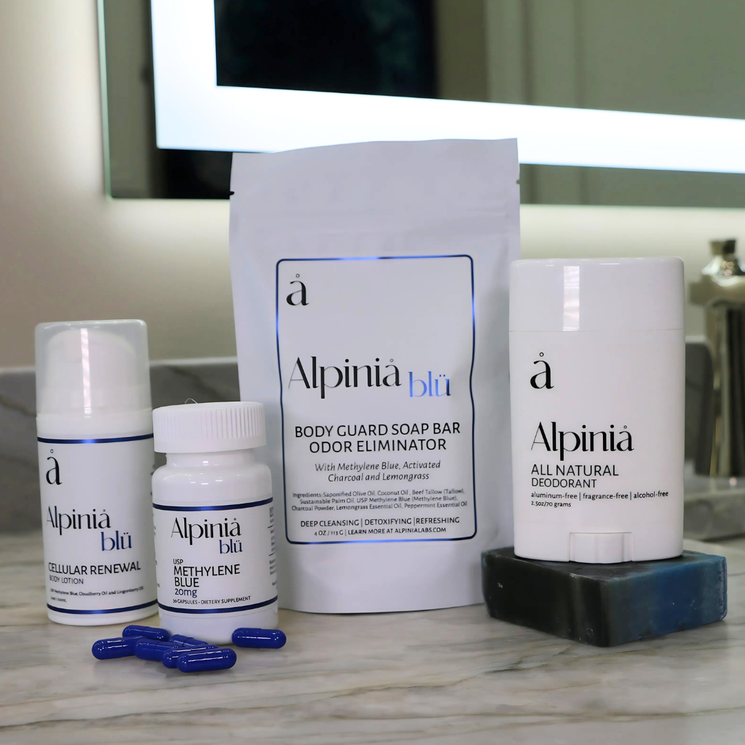 Full body wellness kit including white deodorant, soap, blue Methylene Blue capsules, and body lotion on a marble surface